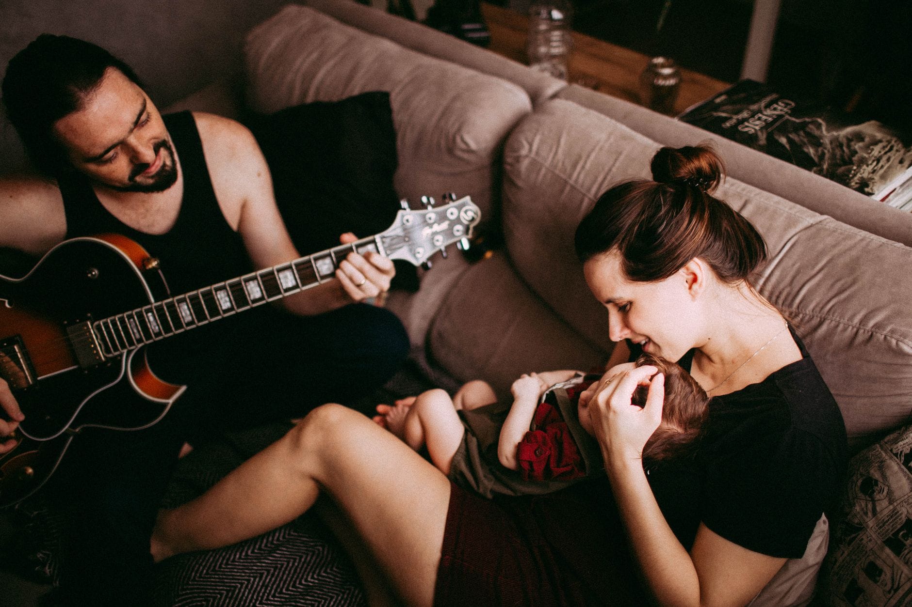 Rodzina w domu wspólnie słucha muzyki i gra na gitarze
